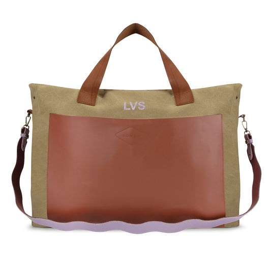 The LVS Betty in butterscotch canvas with a tan leather front pocket, LVS embroidered in lilac, and a wavy lilac and plum leather strap.
